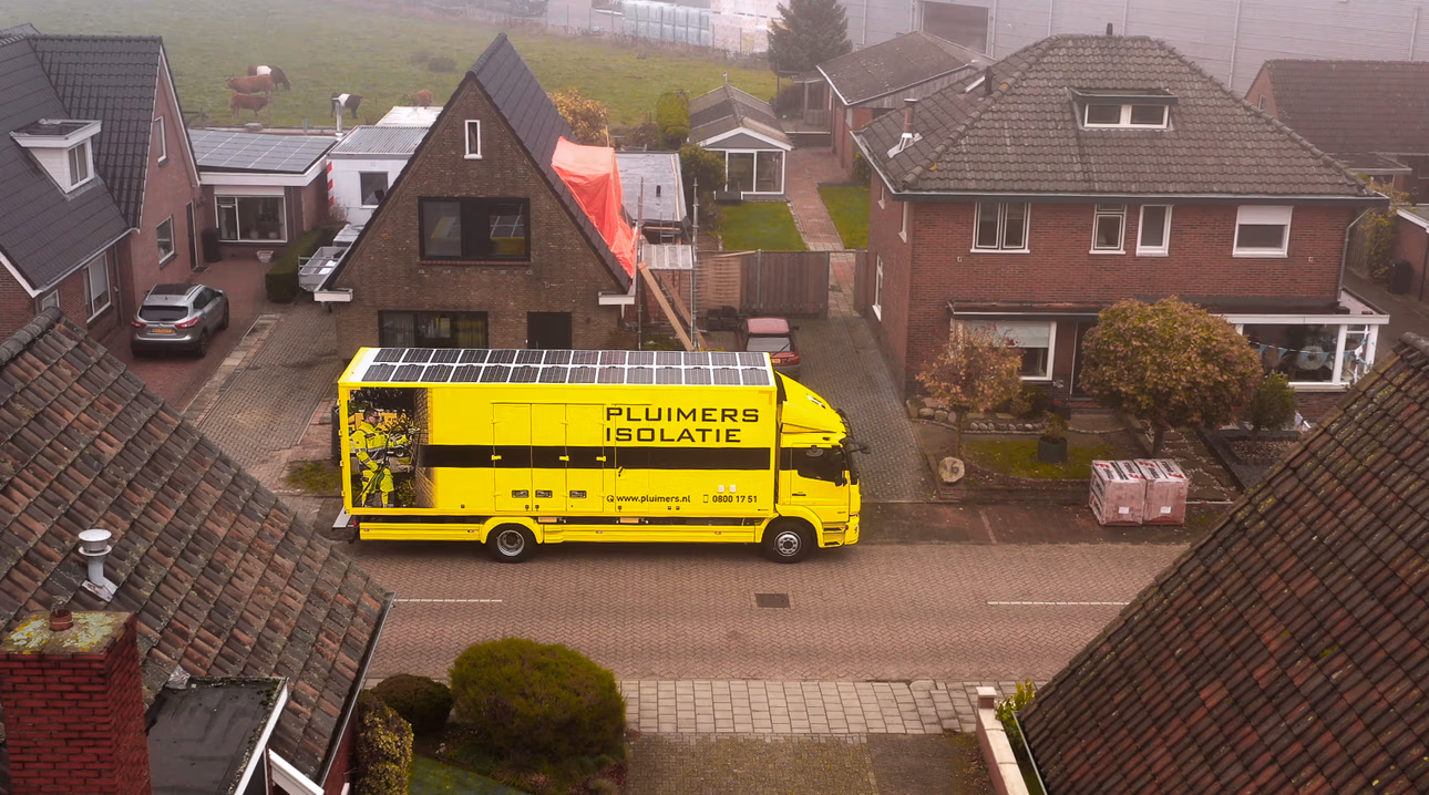 Afbeelding van een straat met Pluimers Isolatie vrachtwagen geparkeerd